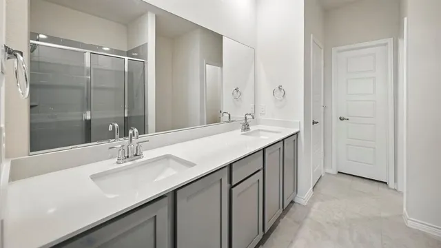 a bathroom with a double vanity sink mirror and shower