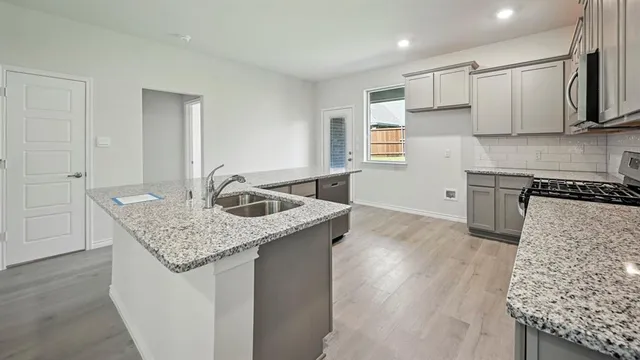 a kitchen with stainless steel appliances granite countertop a sink stove and cabinets