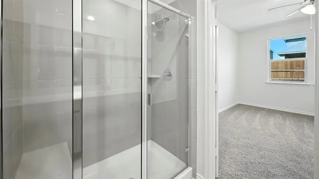 a bathroom with a shower and a glass door
