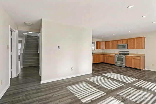 a view of a kitchen with wooden floor and electronic appliances