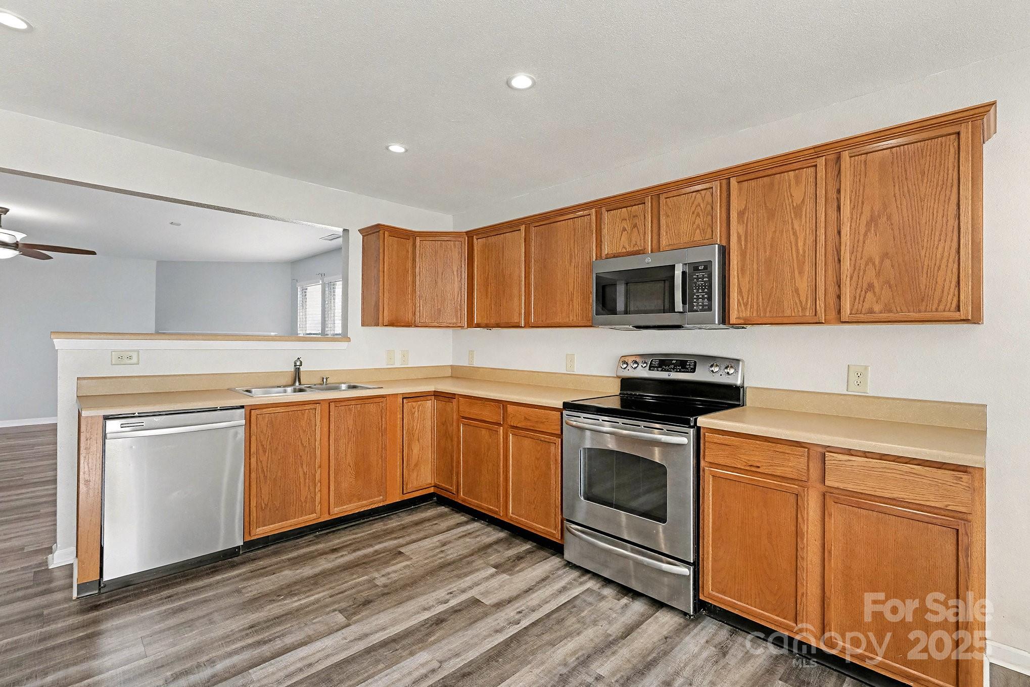 3901 Shasta Circle Clover, SC 29710 - Photo 15 of 36 a kitchen with granite countertop wood cabinets stainless steel appliances and a sink
