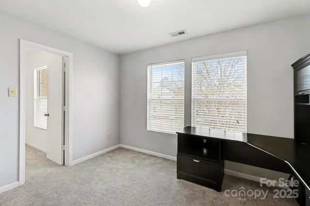 a view of an empty room with a chandelier fan