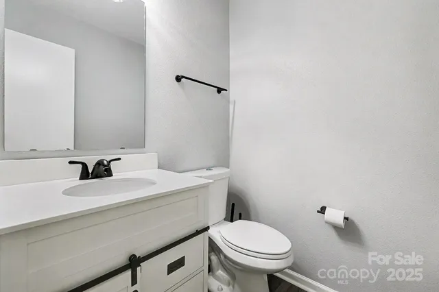 an empty room with a chandelier fan and windows