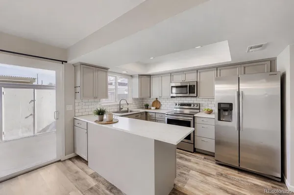 a kitchen with stainless steel appliances a refrigerator sink and microwave