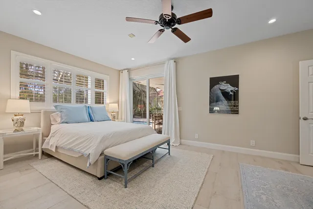 a spacious bedroom with a bed and glass door