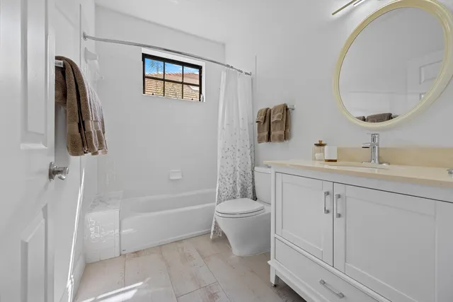 a bathroom with a double vanity sink toilet and shower