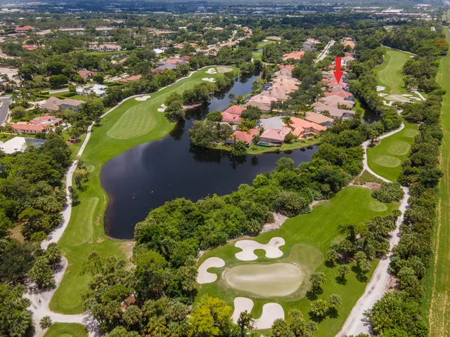 an aerial view of a house with a yard and green space