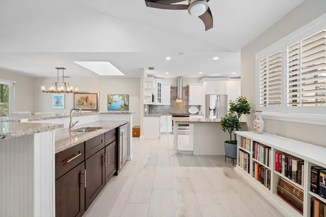 a large kitchen with stainless steel appliances lots of counter space and a sink