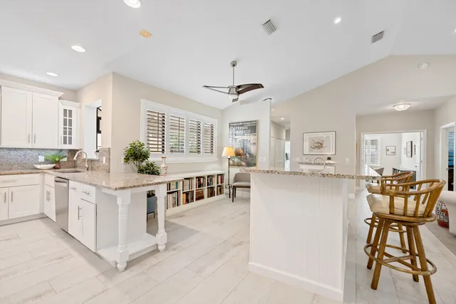 a kitchen with stainless steel appliances white cabinets and wooden floor