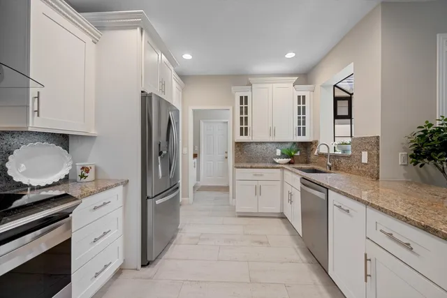 a kitchen with stainless steel appliances granite countertop a refrigerator and a stove