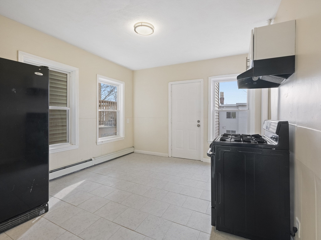 75 Bellingham Street Chelsea, MA 02150 - Photo 13 of 42 a kitchen with a black stove and white cabinets