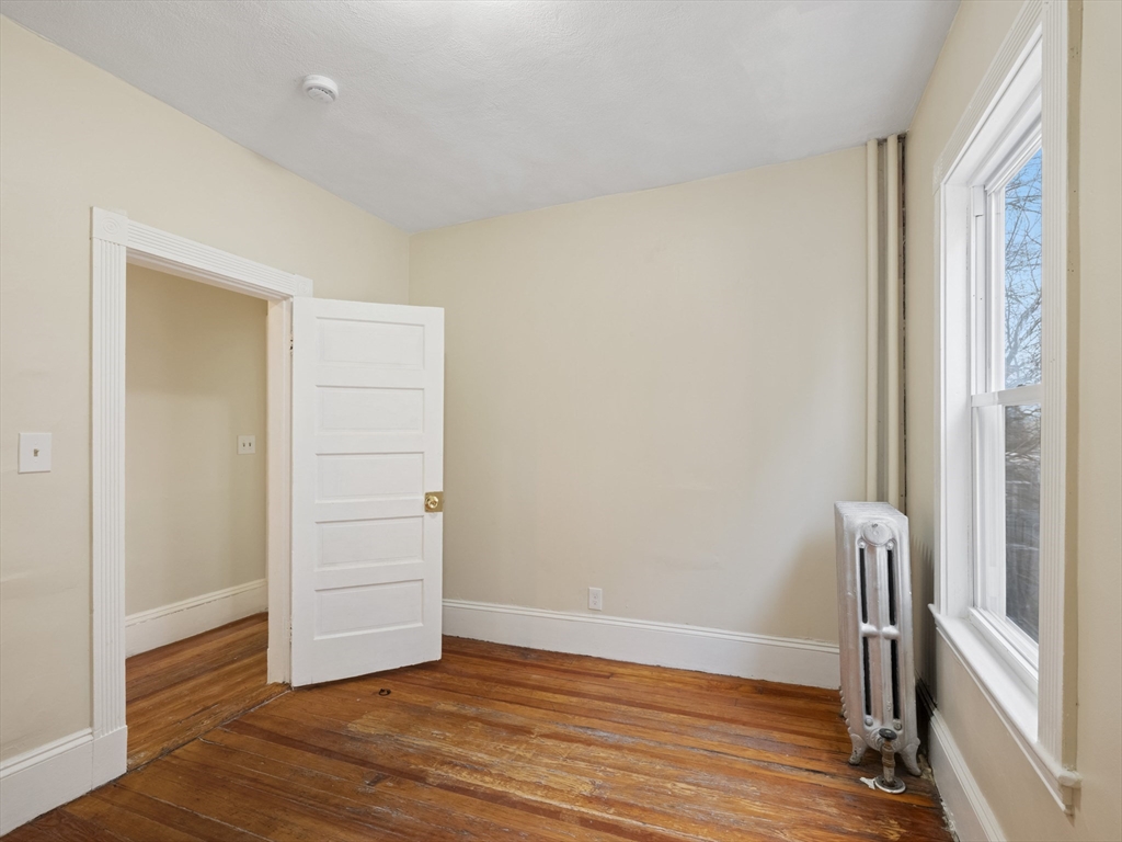 75 Bellingham Street Chelsea, MA 02150 - Photo 25 of 42 an empty room with wooden floor and a window
