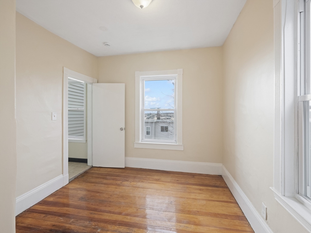 75 Bellingham Street Chelsea, MA 02150 - Photo 33 of 42 a view of an empty room with wooden floor and a window