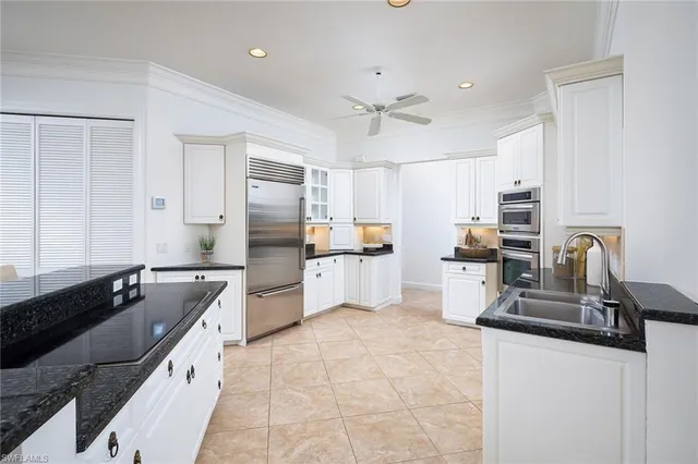 a kitchen with granite countertop a sink counter top space appliances and cabinets