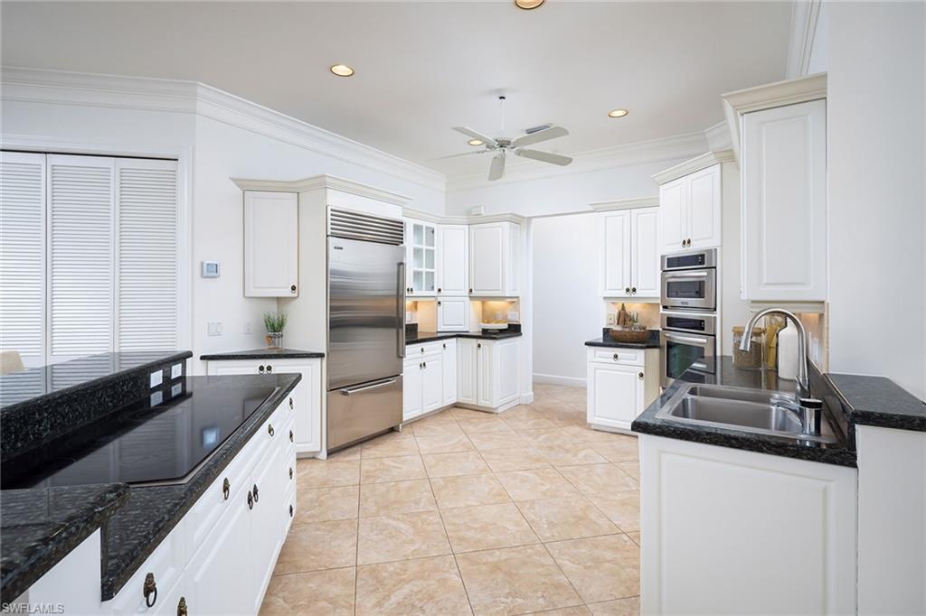 896 Barcarmil Way Naples, FL 34110 - Photo 15 of 45 a kitchen with granite countertop a sink counter top space appliances and cabinets
