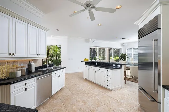 a kitchen with granite countertop a refrigerator and a sink