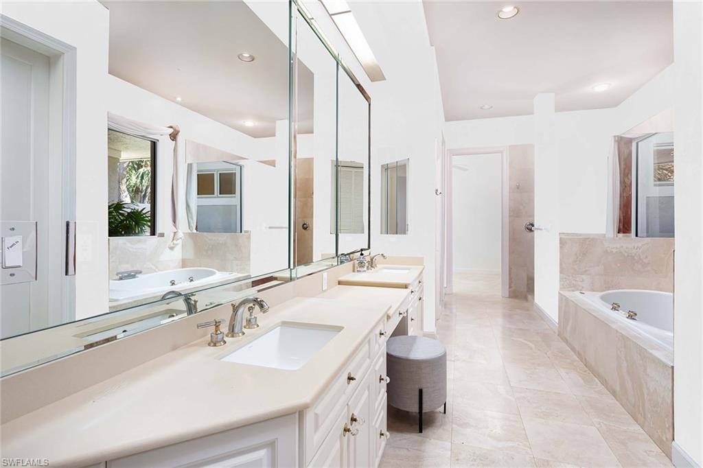 896 Barcarmil Way Naples, FL 34110 - Photo 19 of 45 a bathroom with a double vanity sink toilet mirror and bathtub