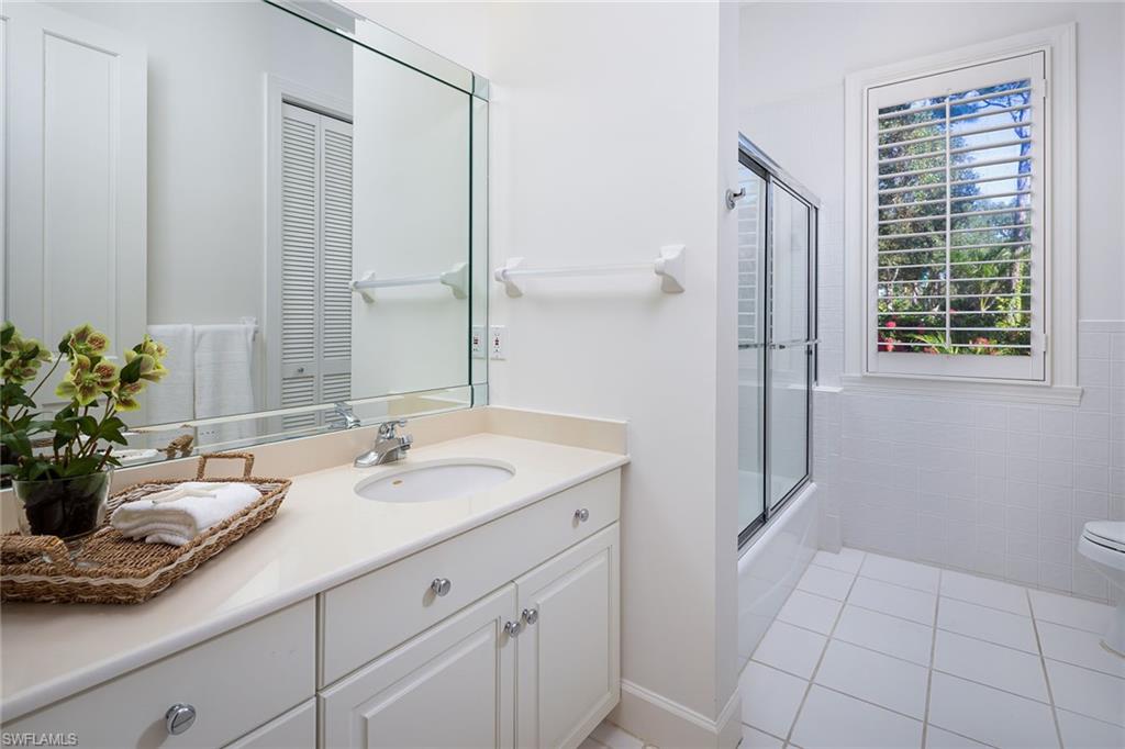 896 Barcarmil Way Naples, FL 34110 - Photo 26 of 45 a bathroom with a sink a mirror and a shower