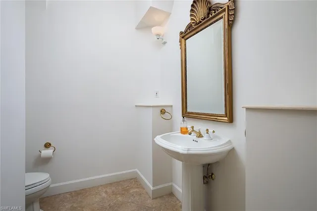a bathroom with a sink a toilet and mirror