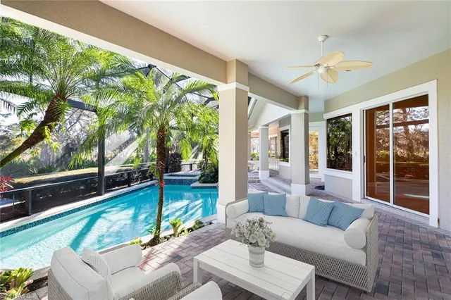 a living room with patio furniture and a large window