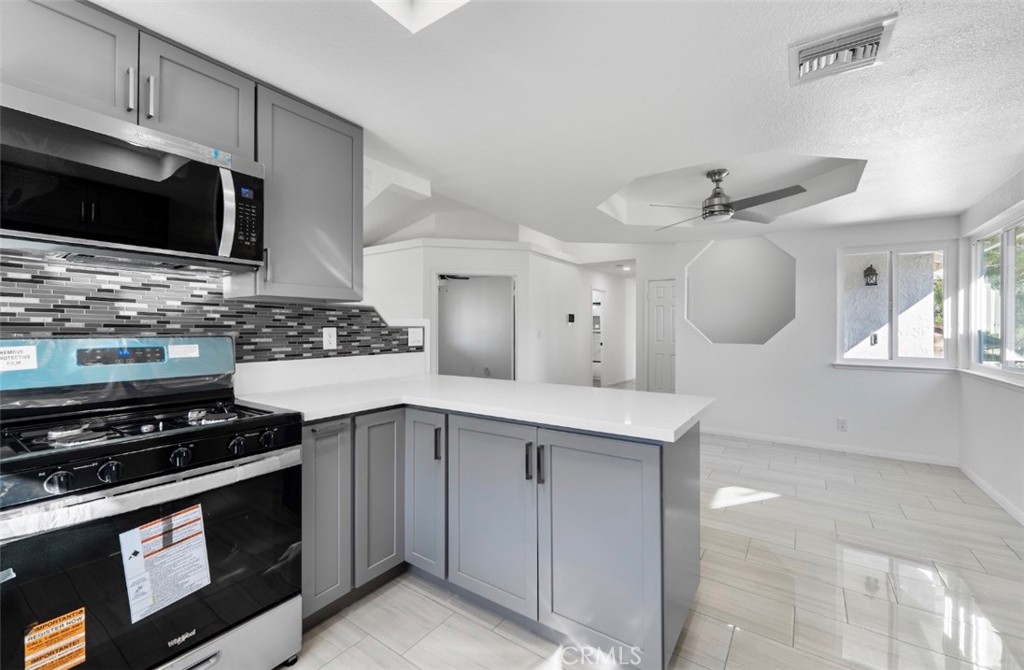 15352 Linden Street Hesperia, CA 92345 - Photo 12 of 39 a kitchen with stainless steel appliances a stove microwave and cabinets