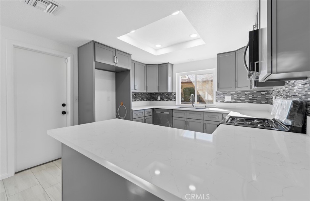 15352 Linden Street Hesperia, CA 92345 - Photo 14 of 39 a large white kitchen with cabinets and stainless steel appliances