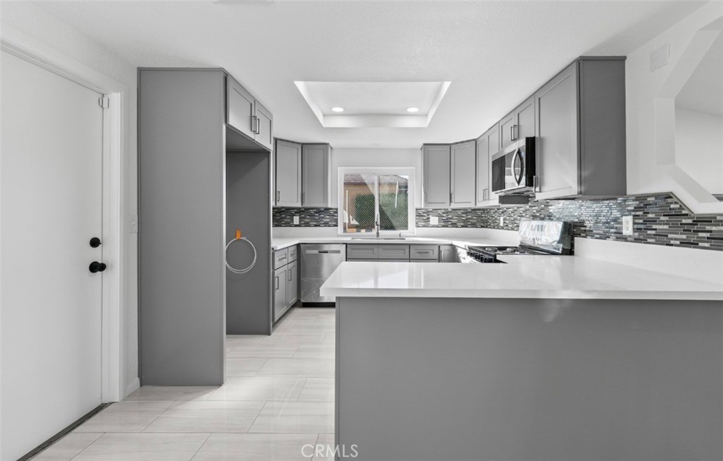 15352 Linden Street Hesperia, CA 92345 - Photo 10 of 39 a kitchen with stainless steel appliances a sink a stove a refrigerator and cabinets