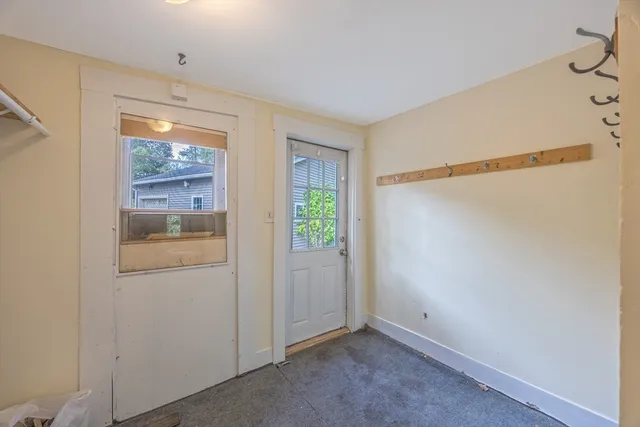 a view of a house with a big yard potted plants and large tree