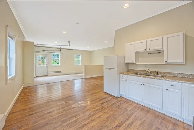 a kitchen with granite countertop a refrigerator stove and sink