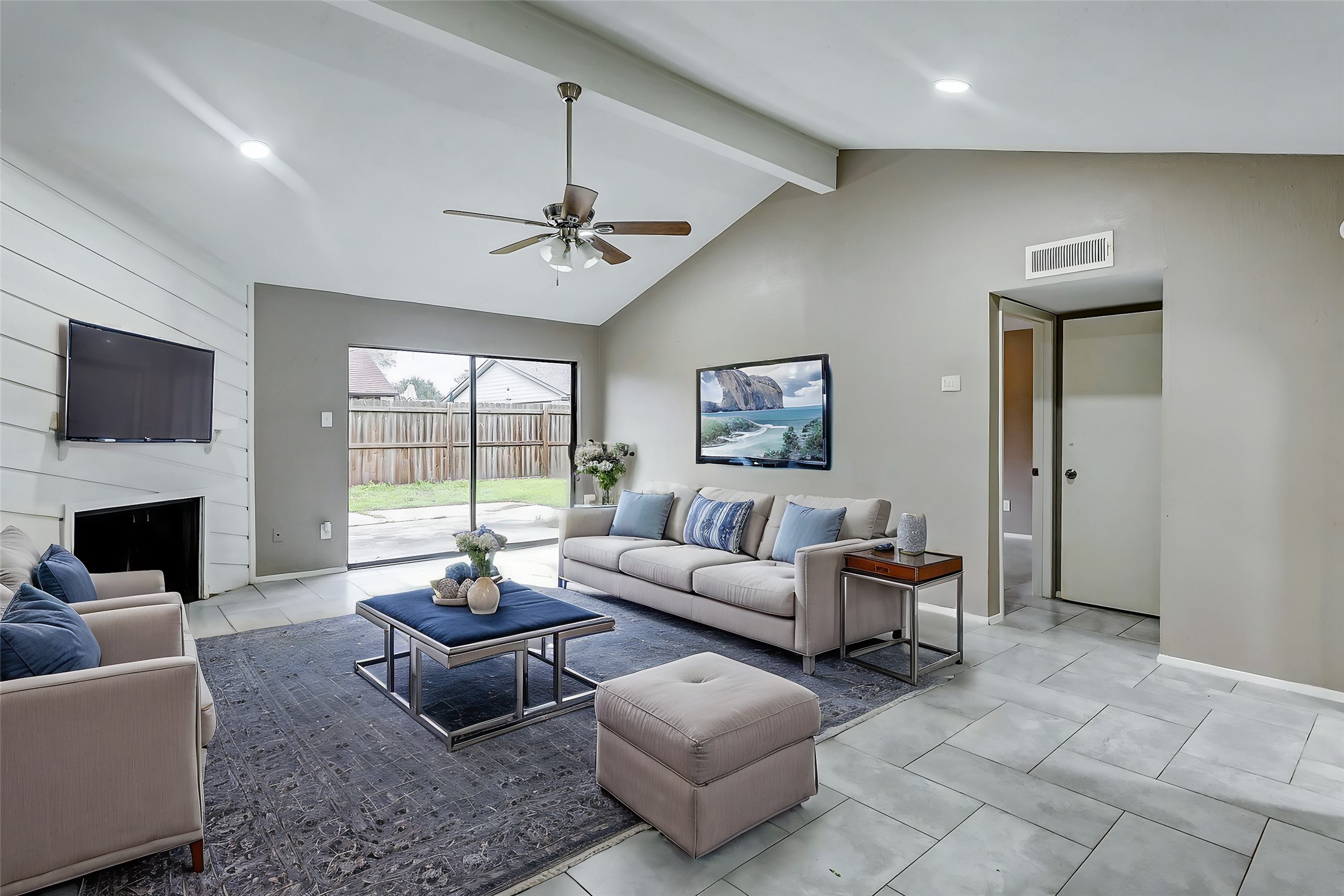 a living room with furniture a fireplace and a flat screen tv