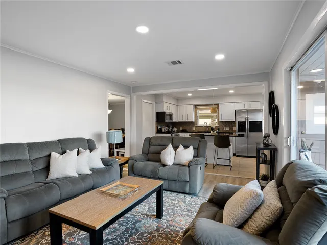 a living room with furniture kitchen view and a table