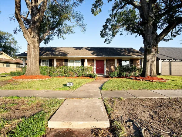 a front view of a house with a yard and potted plants