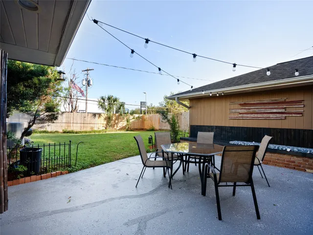 a view of a patio with a table and chairs under an umbrella