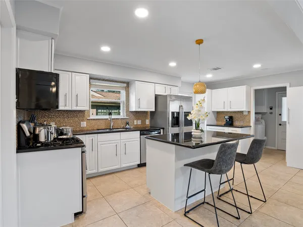 a kitchen with stainless steel appliances kitchen island granite countertop a sink and cabinets