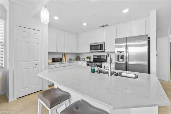 a kitchen with kitchen island a counter top space appliances and cabinets