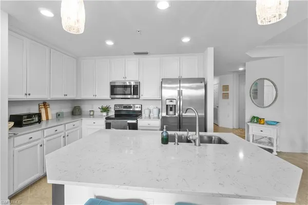 a kitchen with stainless steel appliances granite countertop a sink a stove cabinets and a refrigerator
