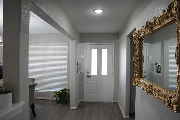 a view of a hallway with wooden floor and windows