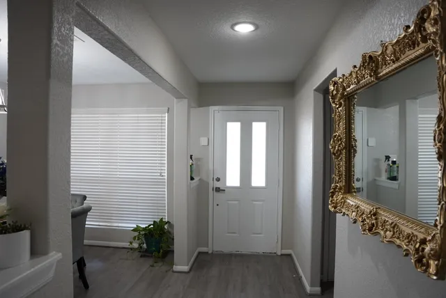 a view of a hallway with wooden floor and windows