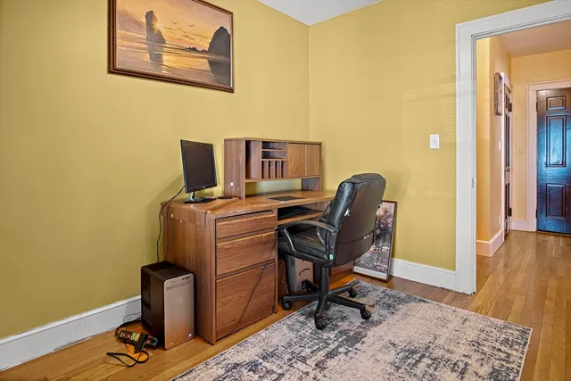 a view of a workspace with furniture and wooden floor