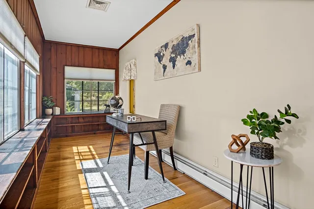 a dining room with furniture a rug and a potted plant