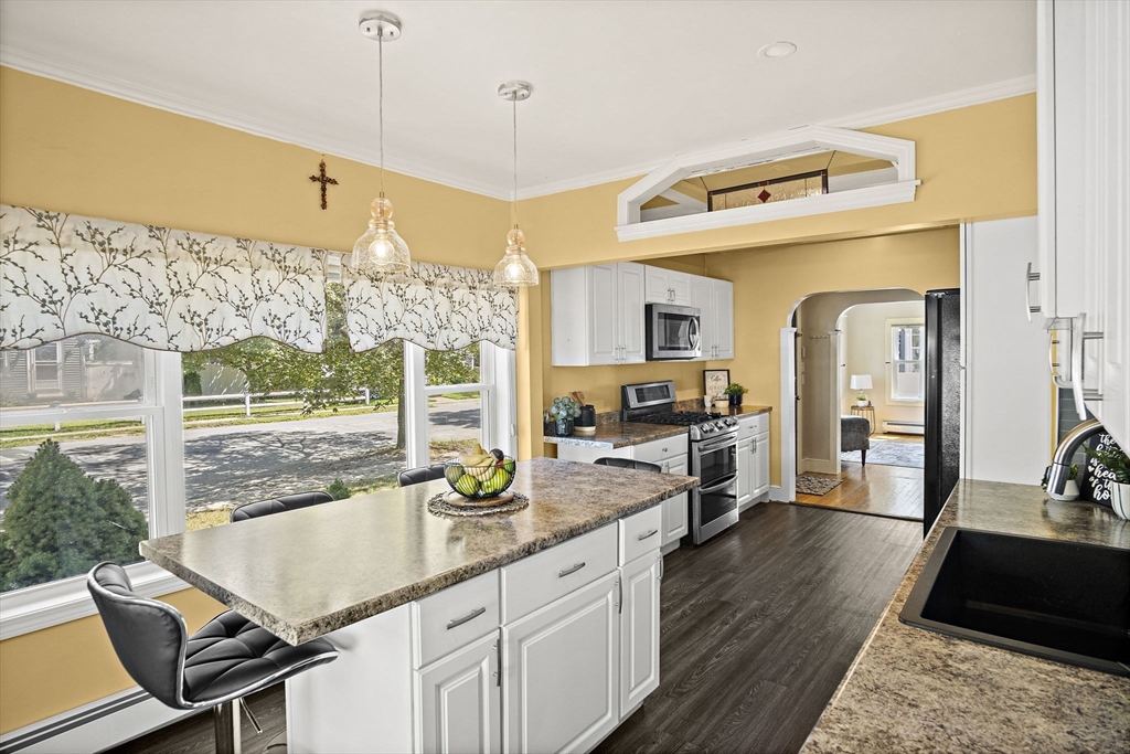 56 Summer Street Saugus, MA 01906 - Photo 7 of 29 a view of a kitchen with kitchen island granite countertop wooden floor and a view of living room