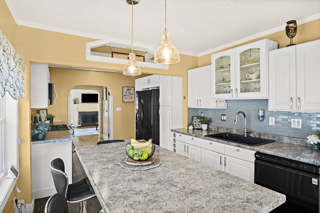 56 Summer Street Saugus, MA 01906 - Photo 8 of 29 a kitchen with stainless steel appliances granite countertop a stove a refrigerator a sink a dining table and chairs with wooden floor