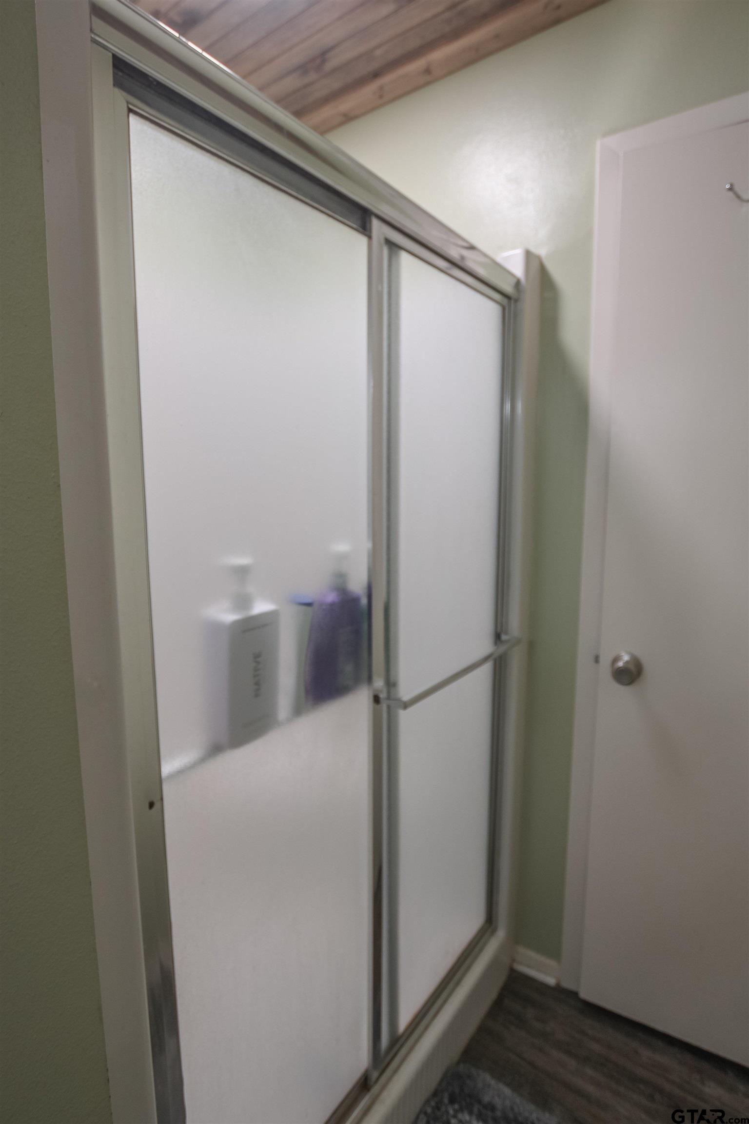 7546 Hill N Dale Road Tyler, TX 75709 - Photo 13 of 24 a bathroom with a glass shower door