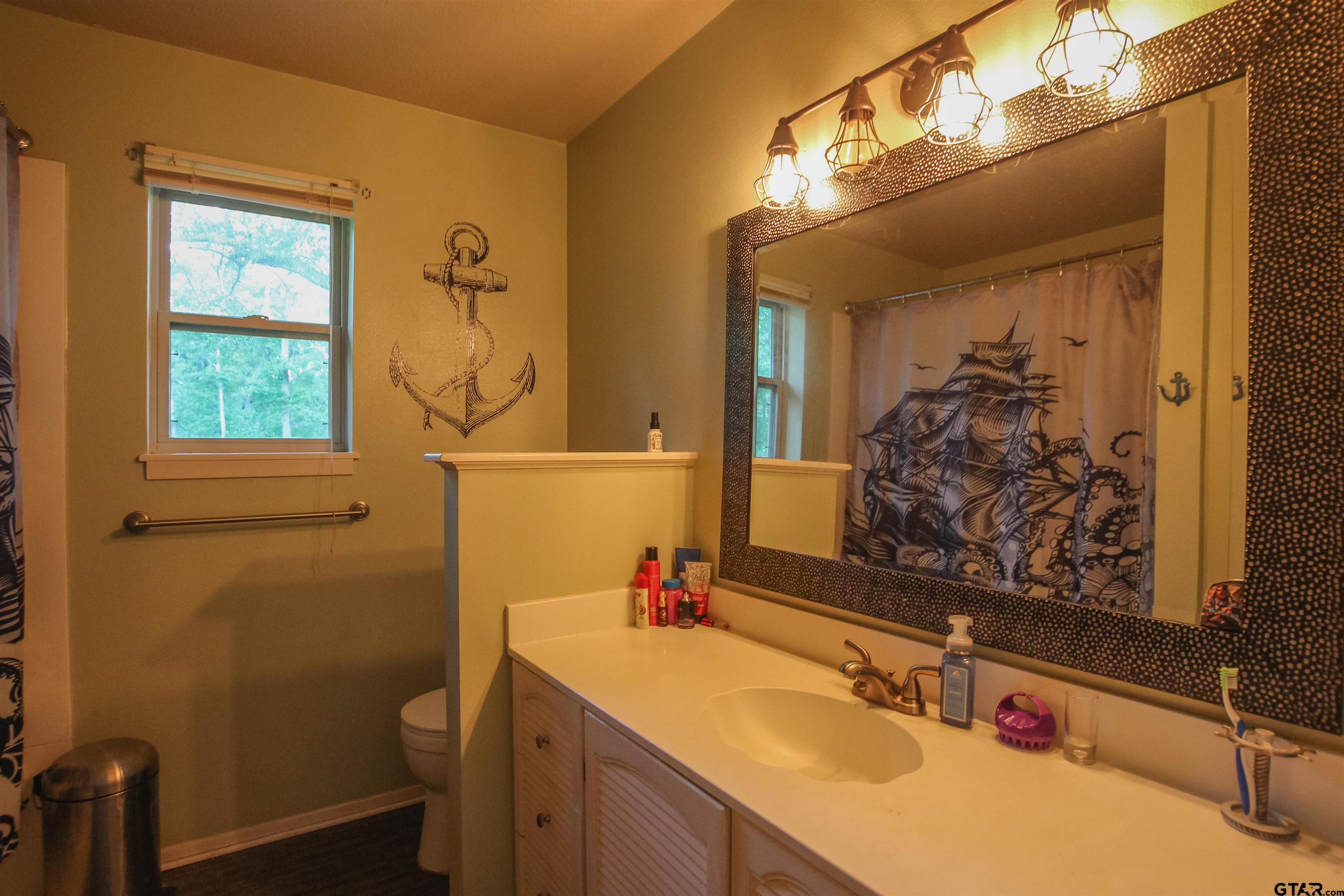 7546 Hill N Dale Road Tyler, TX 75709 - Photo 14 of 24 a bathroom with a sink vanity mirror and toilet