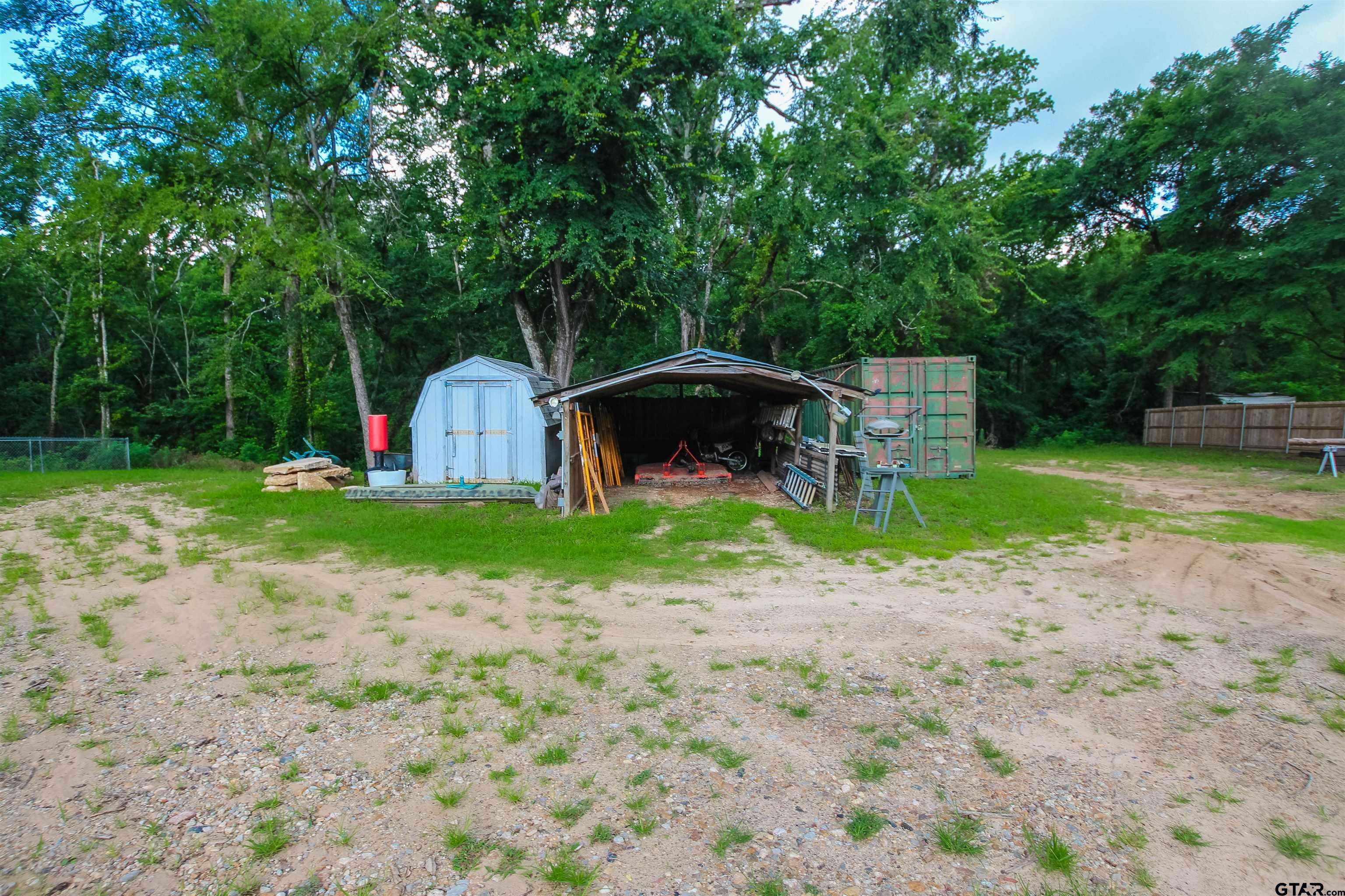 7546 Hill N Dale Road Tyler, TX 75709 - Photo 22 of 24 a view of a backyard with a small cabin