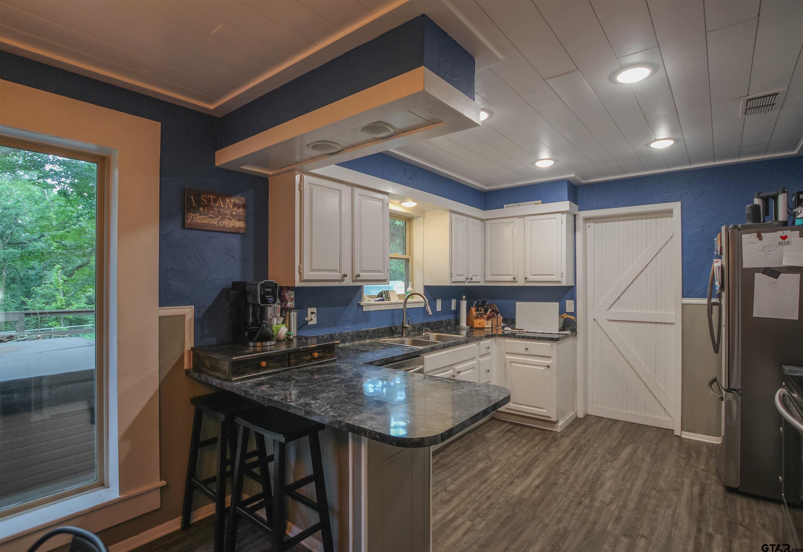 7546 Hill N Dale Road Tyler, TX 75709 - Photo 7 of 24 a kitchen with kitchen island a counter top space a sink appliances and cabinets