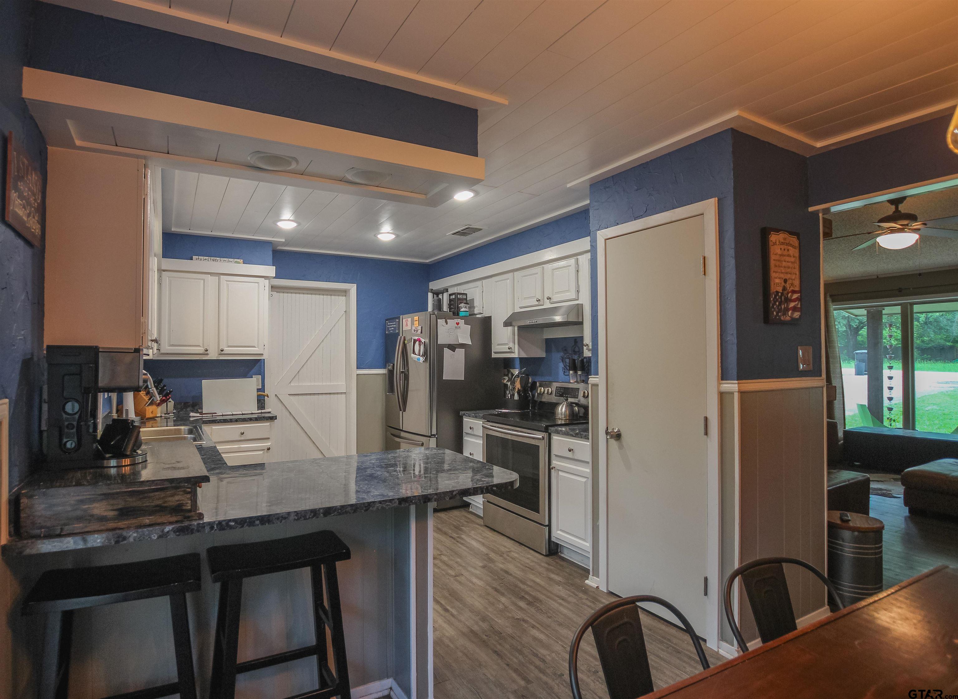 7546 Hill N Dale Road Tyler, TX 75709 - Photo 8 of 24 a kitchen with refrigerator and cabinets