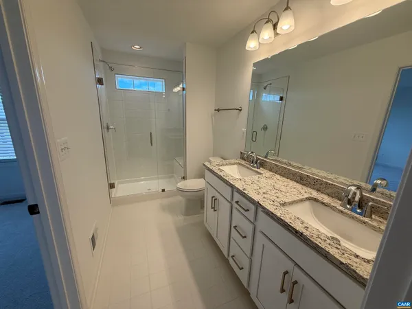a spacious bathroom with a granite countertop sink mirror and a bathtub