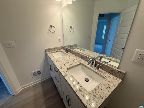 a bathroom with a granite countertop sink and a mirror