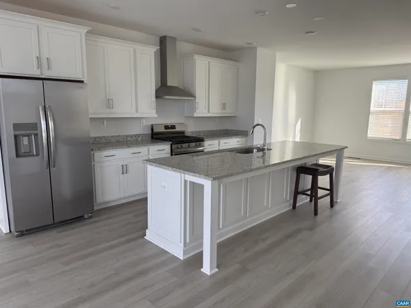 a kitchen with stainless steel appliances granite countertop white cabinets stove a sink and dishwasher with wooden floor